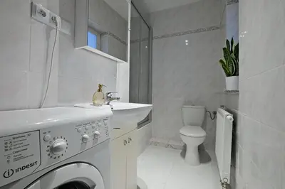 a white bathroom with a washing machine and a sink at Urban Nest Apartments Radziwiłłowska 12 in Kraków