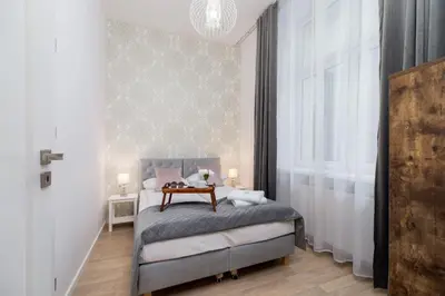 a bedroom with a bed with a table on it at Beautiful Apartments Kraków Dietla by Noclegi Renters in Kraków