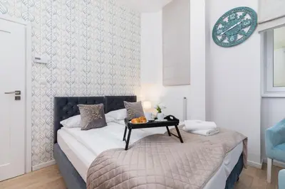 a bedroom with a bed with a table on it at Beautiful Apartments Kraków Dietla by Noclegi Renters in Kraków