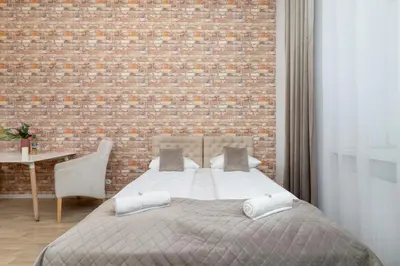 a bedroom with a bed and a brick wall at Beautiful Apartments Kraków Dietla by Noclegi Renters in Kraków