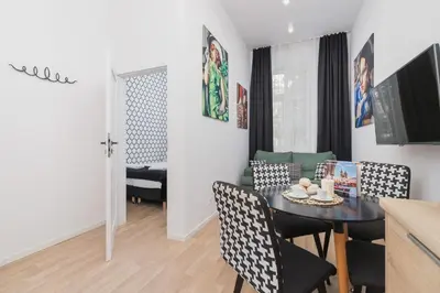 a dining room and living room with a table and chairs at Beautiful Apartments Kraków Dietla by Noclegi Renters in Kraków