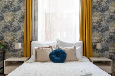a bedroom with a bed with a blue pillow on it at Luxe Living Castle View in Kraków