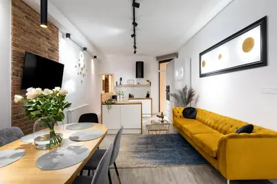 a living room with a yellow couch and a table at Luxe Living Castle View in Kraków
