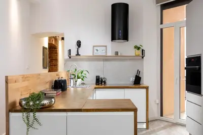 a kitchen with white cabinets and a wooden counter top at Luxe Living Castle View in Kraków