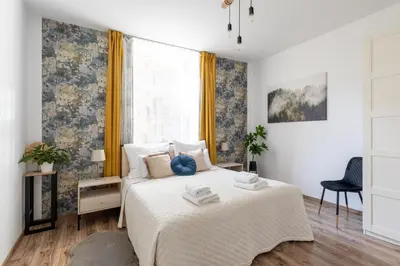 a white bedroom with a bed and a window at Luxe Living Castle View in Kraków
