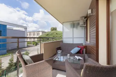 a balcony with a table and chairs on a balcony at Kraków Błonia Apartment with Balcony by Noclegi Renters in Kraków