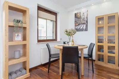 a dining room with a table and chairs at Kraków Błonia Apartment with Balcony by Noclegi Renters in Kraków