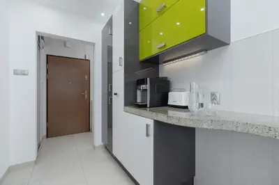 a kitchen with a counter top with a microwave at Kraków Błonia Apartment with Balcony by Noclegi Renters in Kraków