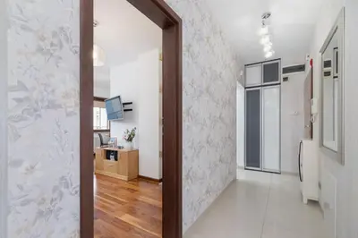 a hallway with a door leading into a room with a kitchen at Kraków Błonia Apartment with Balcony by Noclegi Renters in Kraków