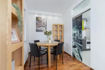 a dining room with a table and chairs at Kraków Błonia Apartment with Balcony by Noclegi Renters in Kraków