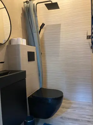 a bathroom with a black toilet and a sink at Apartment Ida, Kazimierz center in Kraków