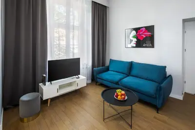 a living room with a blue couch and a tv at Modern & cozy flat - near to Wawel Castle in Kraków