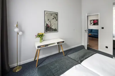 a bedroom with a bed and a table with a vase on it at Modern & cozy flat - near to Wawel Castle in Kraków
