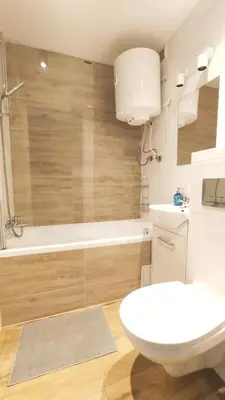 a bathroom with a toilet and a tub and a sink at Na Szaniec 17 by Homeprime in Kraków