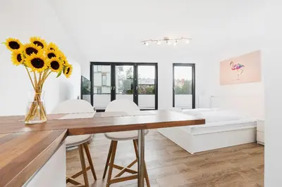 a dining room with a table and a vase of sunflowers at Mieszczańska 10 by Homeprime in Kraków