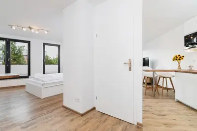 a white room with a bed and a table at Mieszczańska 10 by Homeprime in Kraków