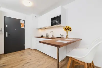 a kitchen with white cabinets and a wooden counter top at Mieszczańska 10 by Homeprime in Kraków