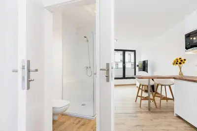 a bathroom with a shower and a table with chairs at Mieszczańska 10 by Homeprime in Kraków