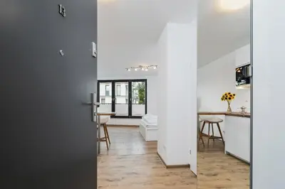 a kitchen and living room with white walls and a sliding door at Mieszczańska 10 by Homeprime in Kraków
