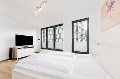a white bedroom with a bed and a flat screen tv at Mieszczańska 10 by Homeprime in Kraków