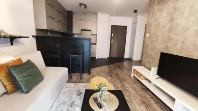 a living room with a white couch and a tv at Wrocławska 53L by Homeprime in Kraków