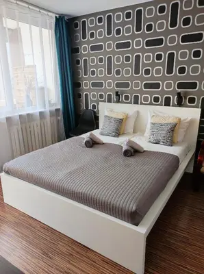 a bedroom with a white bed with a wall with at Apartament 88 in Kraków