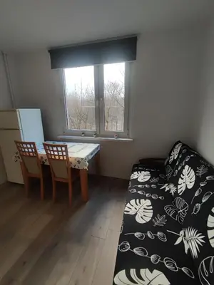 a room with a table and a bed and a window at Apartament 88 in Kraków