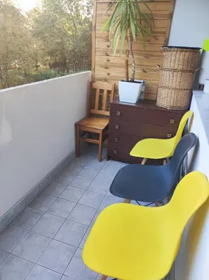 a balcony with two yellow chairs and a dresser at Apartament 88 in Kraków