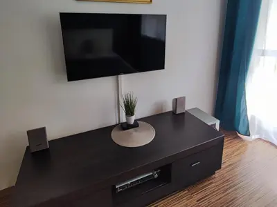 a black entertainment center with a tv on a wall at Apartament 88 in Kraków