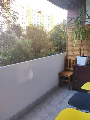 a balcony with a table and a chair and a window at Apartament 88 in Kraków