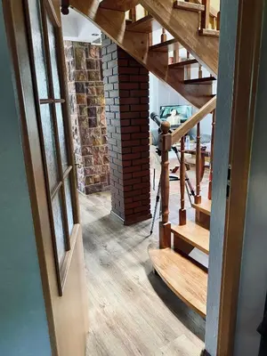 an open hallway with wooden stairs and a brick wall at Zielony Dom in Węglówka