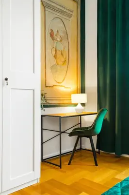 a desk with a green chair in a room at Glamorous Apartment in heart of Old Town in Kraków