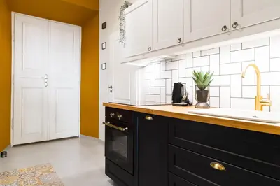 a kitchen with black cabinets and a sink at Glamorous Apartment in heart of Old Town in Kraków