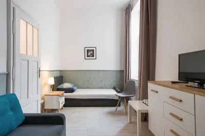 a small living room with a bed and a tv at Near the Royal Castle in Kraków