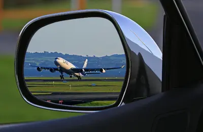 a reflection of an airplane in the side view mirror of a car at Near the Royal Castle in Kraków