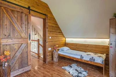 a room with a bed and a wooden door at Leśne Zacisze in Nowy Targ