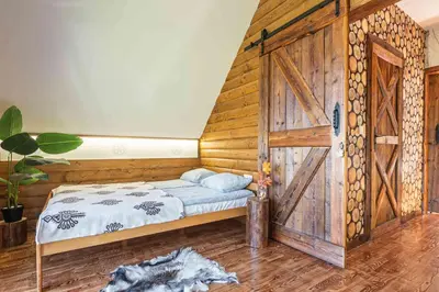 a bedroom with a bed with a wooden wall at Leśne Zacisze in Nowy Targ