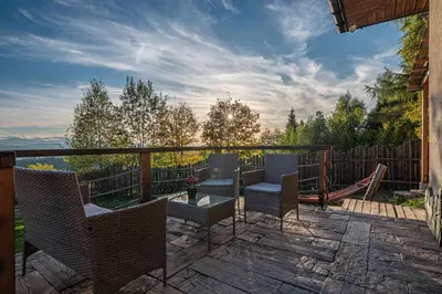 a patio with chairs and a hammock on a deck at Leśne Zacisze in Nowy Targ