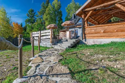 a log house with a fence and a stone path at Leśne Zacisze in Nowy Targ