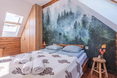 a bedroom with a large painting on the wall at Leśne Zacisze in Nowy Targ