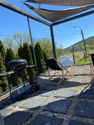 a grill and a chair on a patio at Stodoła Nad Skawą in Sucha Beskidzka