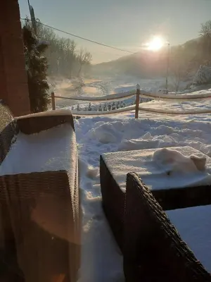 a snow covered yard with the sun in the background at Stodoła Nad Skawą in Sucha Beskidzka