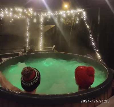 two people sitting in a hot tub with lights at Stodoła Nad Skawą in Sucha Beskidzka