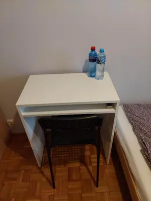 two bottles of water sitting on a desk with a chair at Mieszkanie na Mickiewicza 7 in Olkusz