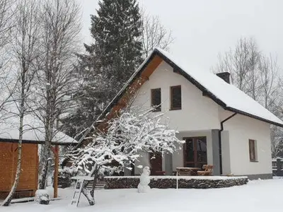 a white house with snow on the roof at Domek w Zawoi Chwilo Trwaj in Zawoja