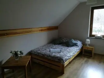 a bedroom with a bed with a book on it at Domek w Zawoi Chwilo Trwaj in Zawoja