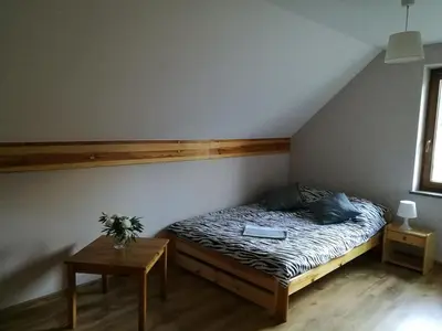 a bedroom with a bed with a laptop on it at Domek w Zawoi Chwilo Trwaj in Zawoja