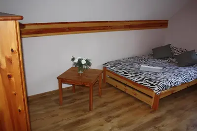 a bedroom with a bed and a table with flowers at Domek w Zawoi Chwilo Trwaj in Zawoja