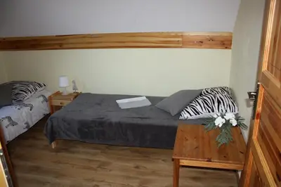 a bedroom with a bed with a book on it at Domek w Zawoi Chwilo Trwaj in Zawoja
