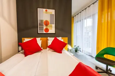 a bedroom with a bed with red pillows at Vintage Rakowicka Apartment in Kraków